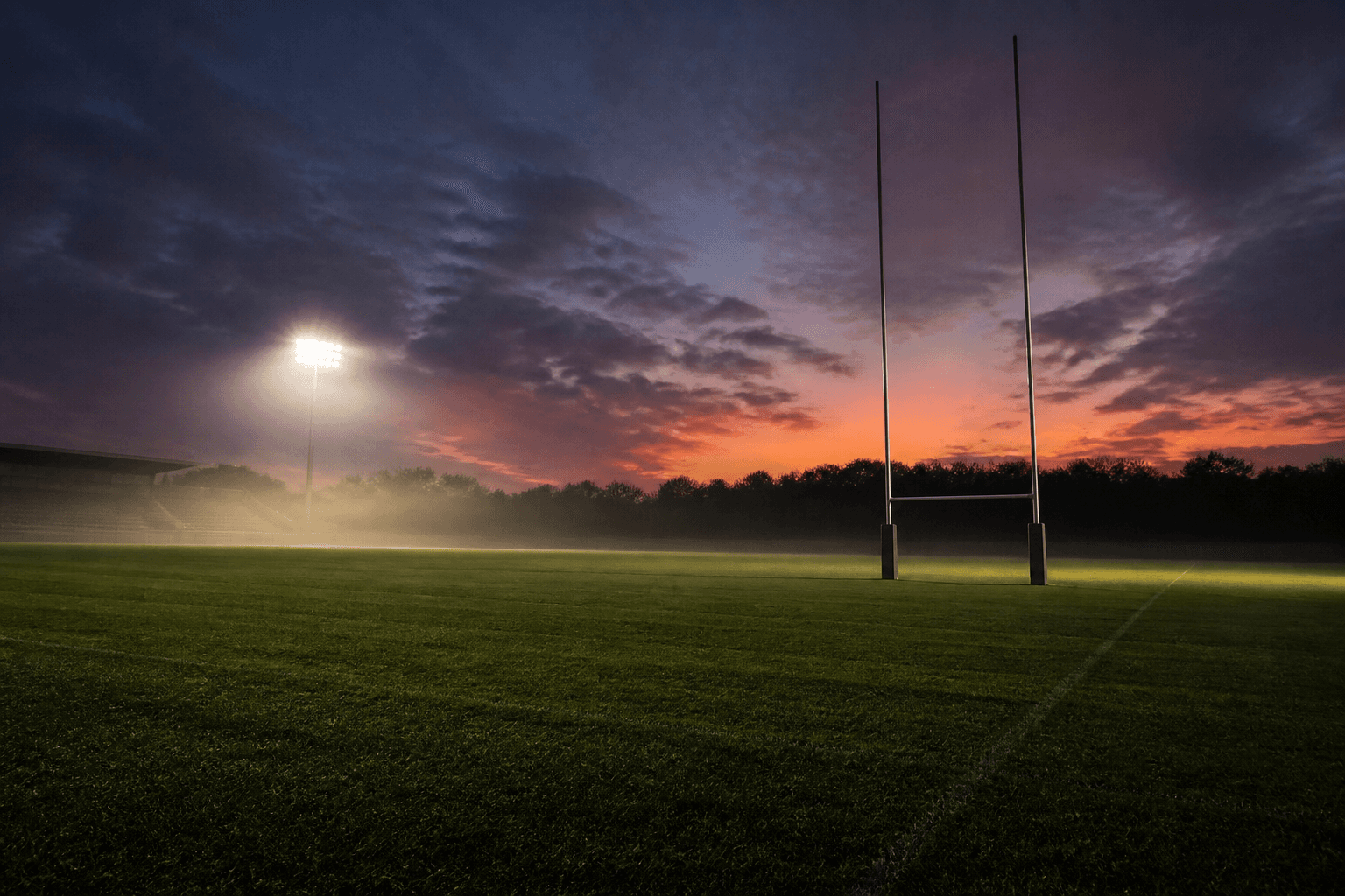 Terrain de rugby au soir, poteaux en H sans écusson.